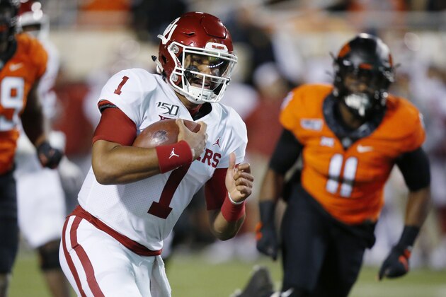 Oklahoma quarterback Jalen Hurts (1) carries past Oklahoma State linebacker Amen Ogbongbemiga (11) for a touchdown in the first half of an NCAA college football game in Stillwater, Okla., Saturday, Nov. 30, 2019. (AP Photo/Sue Ogrocki)