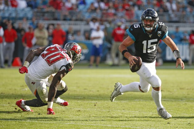 Jacksonville Jaguars quarterback Gardner Minshew (15) scrambles away from Tampa Bay Buccaneers linebacker Jason Pierre-Paul (90) during the second half of an NFL football game, Sunday Dec. 1, 2019, in Jacksonville, Fla. (AP Photo/Stephen B. Morton)