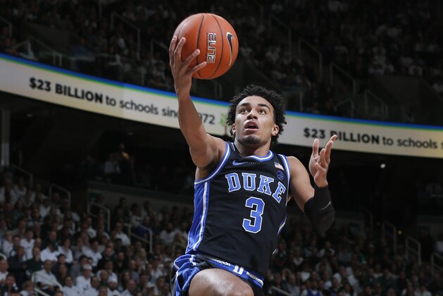 Duke's Tre Jones, top, goes over Michigan State's Foster Loyer for a layup during the first half of an NCAA college basketball game, Tuesday, Dec. 3, 2019, in East Lansing, Mich. (AP Photo/Al Goldis)