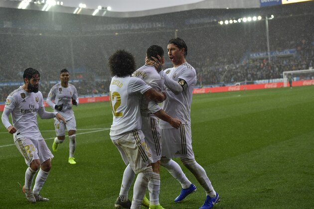 Real Madrid's Dani Carvajal, second right, celebrates with teammates Sergio Ramos, right, and Marcelo after scoring his side's second goal during the Spanish La Liga soccer match between Real Madrid and Alaves at Mendizorroza stadium, in Vitoria, northern Spain, Saturday, Nov. 30, 2019. (AP Photo/Alvaro Barrientos)