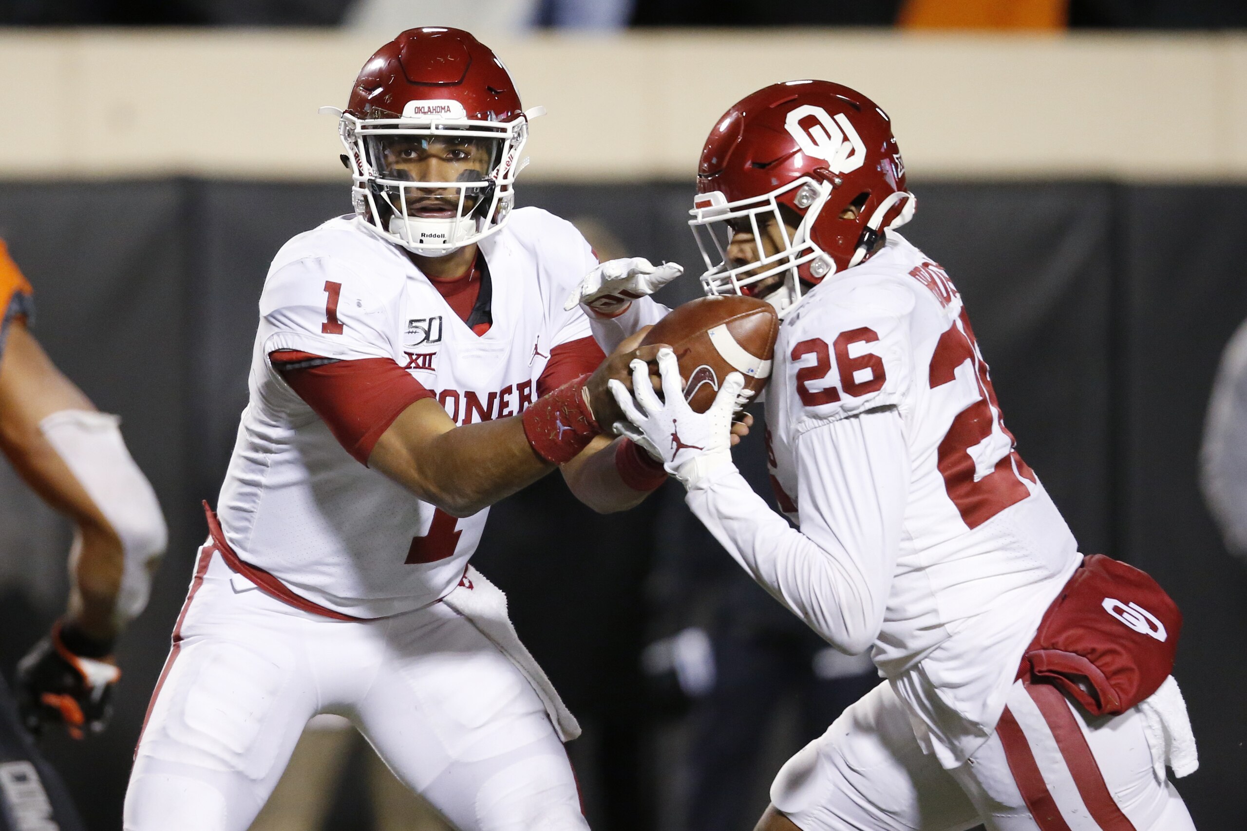 Oklahoma quarterback Jalen Hurts (1) hands off to running back Kennedy Brooks (26) during an NCAA college football game in Stillwater, Okla., Saturday, Nov. 30, 2019. (AP Photo/Sue Ogrocki)