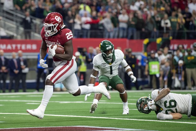 Oklahoma running back Rhamondre Stevenson (29) crosses the goal line for a touchdown run in front of Baylor linebacker Terrel Bernard (26) and cornerback Grayland Arnold (1) during overtime in an NCAA college football game for the Big 12 Conference championship, Saturday, Dec. 7, 2019, in Arlington, Texas. Oklahoma won 30-23. (AP Photo/Jeffrey McWhorter)