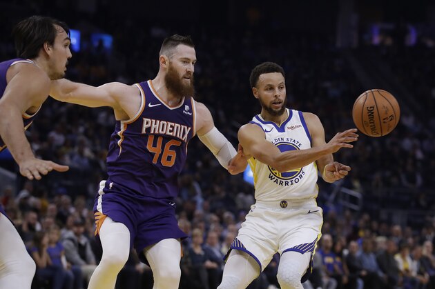 Golden State Warriors' Stephen Curry, right, passes the ball away from Phoenix Suns' Aron Baynes (46) during the first half of an NBA basketball game Wednesday, Oct. 30, 2019, in San Francisco. (AP Photo/Ben Margot)