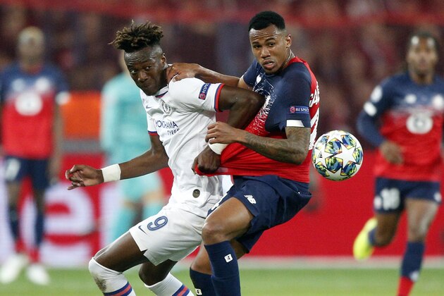 Chelsea's Tammy Abraham, left, fights for the ball with Lille's Gabriel during the group H Champions League soccer match between Lille and Chelsea at the Stade Pierre Mauroy - Villeneuve d'Ascq stadium in Lille, France, Wednesday, Oct. 2, 2019. (AP Photo/Michel Spingler)