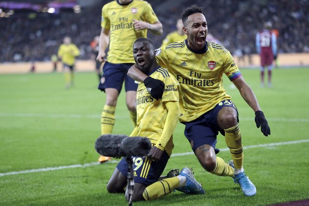 Arsenal's Nicolas Pepe, left, celebrates with Arsenal's Pierre-Emerick Aubameyang after scoring his side's second goal during the English Premier League soccer match between West Ham Utd and Arsenal at the London Stadium in London, Monday, Dec. 9, 2019. (AP Photo/Kirsty Wigglesworth)