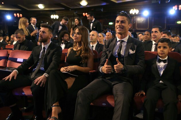 FILE - In this Monday, Oct. 23, 2017 file photo, Portuguese soccer player Christiano Ronaldo, second from right, and son Cristiano Ronaldo Jr., right, sit beside Argentinian soccer player Lionel Messi, left, and wife Antonella during the The Best FIFA 2017 Awards at the Palladium Theatre in London. Cristiano Ronaldo and Lionel Messi put up impressive numbers, in life and on the field, going into a fourth World Cup for each. So much has happened for football's standout stars since the 2014 tournament left both still lacking the game's most coveted prize. (AP Photo/Alastair Grant, File)