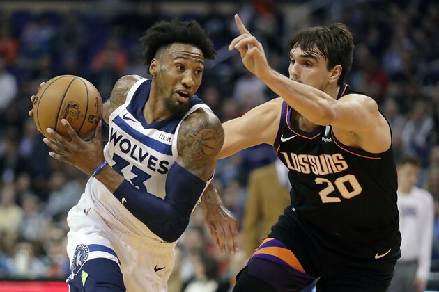 Minnesota Timberwolves forward Robert Covington (33) drives around Phoenix Suns forward Dario Saric (20) during the first half of an NBA basketball game, Monday, Dec. 9, 2019, in Phoenix. (AP Photo/Matt York)
