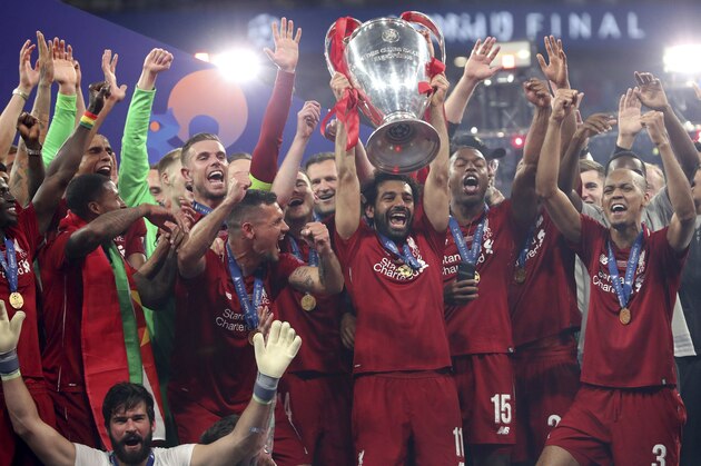 Liverpool's Mohamed Salah lifts the trophy to celebrate with his teammates winning the Champions League final soccer match between Tottenham Hotspur and Liverpool at the Wanda Metropolitano Stadium in Madrid, Saturday, June 1, 2019. (AP Photo/Francisco Seco)