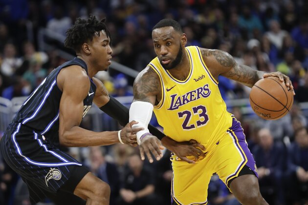 Los Angeles Lakers' LeBron James (23) drives around Orlando Magic's Wes Iwundu, left, during the first half of an NBA basketball game, Wednesday, Dec. 11, 2019, in Orlando, Fla. (AP Photo/John Raoux)