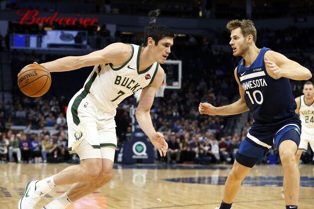 Milwaukee Bucks' Ersan Ilyasova, left, of Turkey, drives as Minnesota Timberwolves' Jake Layman defends in the first half of an NBA basketball game Monday, Nov 4, 2019, in Minneapolis. (AP Photo/Jim Mone)