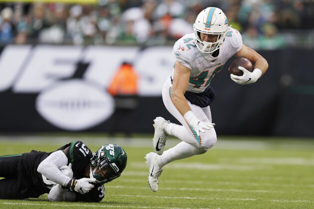 Miami Dolphins running back Patrick Laird (42) runs by New York Jets defensive back Blessuan Austin (31) during the second half of an NFL football game, Sunday, Dec. 8, 2019, in East Rutherford, N.J. (AP Photo/Adam Hunger)