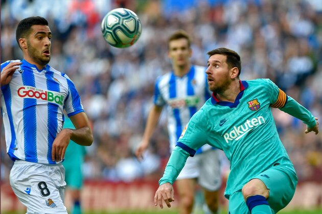 Barcelona's Argentinian forward Lionel Messi (R) vies with Real Sociedad's Spanish midfielder Mikel Merino during the Spanish league football match between Real Sociedad and FC Barcelona at Anoeta stadium in San Sebastian on December 14, 2019. (Photo by ANDER GILLENEA / AFP) (Photo by ANDER GILLENEA/AFP via Getty Images)
