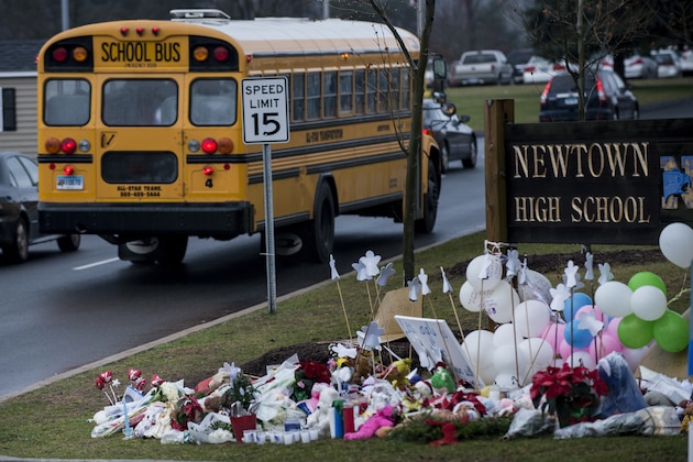 A school bus passes a makeshift memorial to the victims of the Sandy Hook Elementary School shooting as it takes students to Newtown High School December 18, 2012 in Newtown, Connecticut. Students in Newtown, excluding Sandy Hook Elementary School, return to school for the first time since last Friday's shooting at Sandy Hook which took the live of 20 students and 6 adults.  AFP PHOTO/Brendan SMIALOWSKI / AFP / BRENDAN SMIALOWSKI        (Photo credit should read BRENDAN SMIALOWSKI/AFP via Getty Images)