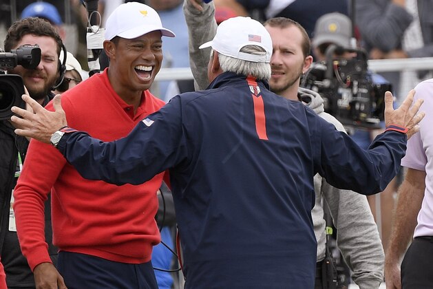 U.S. team player and captain Tiger Woods, left, celebrates with vice captain Fred Couples after Woods won his singles match during the President's Cup golf tournament at Royal Melbourne Golf Club in Melbourne, Sunday, Dec. 15, 2019. (AP Photo/Andy Brownbill)