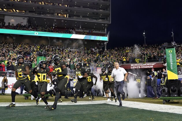Oregon head coach Mario Cristobal, right, leads his players on the field before the start of the Pac-12 Conference championship NCAA college football game against Oregon in Santa Clara, Calif., Friday, Dec. 6, 2018. (AP Photo/Tony Avelar)