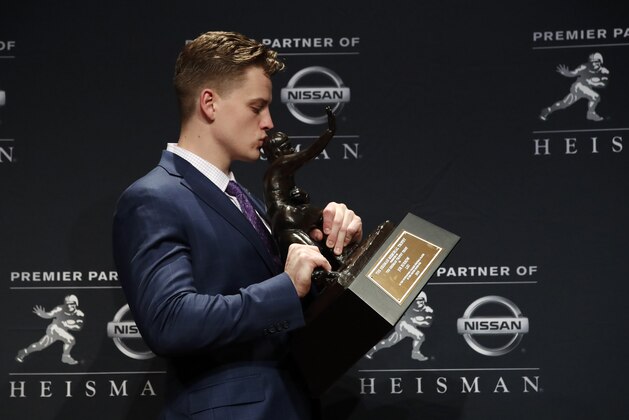 NCAA college football player, LSU quarterback Joe Burrow poses for a photo after winning the Heisman Trophy, Saturday, Dec. 14, 2019, in New York. (AP Photo/Jason Szenes)