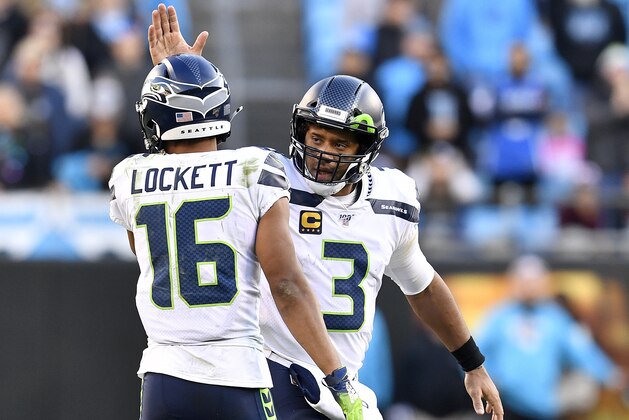 CHARLOTTE, NORTH CAROLINA - DECEMBER 15: Russell Wilson #3 encourages Tyler Lockett #16 of the Seattle Seahawks during the fourth quarter of their game against the Carolina Panthers at Bank of America Stadium on December 15, 2019 in Charlotte, North Carolina. (Photo by Grant Halverson/Getty Images)