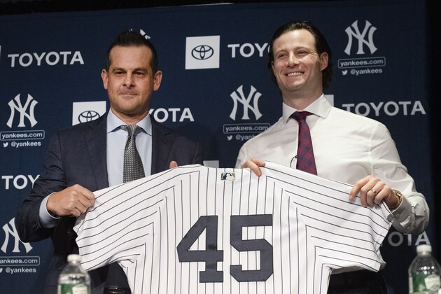 New York Yankees manager Aaron Boone, left, and pitcher Gerrit Cole hold up a jersey as Cole is introduced as the baseball club's newest player during a media availability, Wednesday, Dec. 18, 2019 in New York. The pitcher agreed to a 9-year, $324 million contract. (AP Photo/Mark Lennihan)