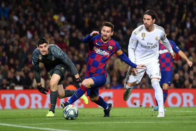 BARCELONA, SPAIN - DECEMBER 18:  Lionel Messi of Barcelona holds off Sergio Ramos of Real Madrid during the Liga match between FC Barcelona and Real Madrid CF at Camp Nou on December 18, 2019 in Barcelona, Spain. (Photo by Alex Caparros/Getty Images)