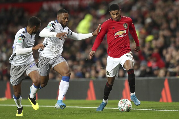 From left, Colchester United's Callum Harriott, Colchester United's Ryan Jackson, and Manchester United's Marcus Rashford vie for the ball during the English League Cup quarter final soccer match between Manchester United and Colchester United at Old Trafford in Manchester, England, Wednesday, Dec. 18, 2019. (AP Photo/Jon Super)