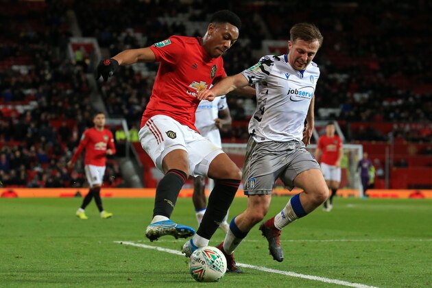 Manchester United's French striker Anthony Martial (L) vies with Colchester United's English midfielder Tom Lapslie (R) during the English League Cup quarter-final football match between Manchester United and Colchester United at Old Trafford in Manchester, north-west England on December 18, 2019. (Photo by Lindsey Parnaby / AFP) / RESTRICTED TO EDITORIAL USE. No use with unauthorized audio, video, data, fixture lists, club/league logos or 'live' services. Online in-match use limited to 120 images. An additional 40 images may be used in extra time. No video emulation. Social media in-match use limited to 120 images. An additional 40 images may be used in extra time. No use in betting publications, games or single club/league/player publications. /  (Photo by LINDSEY PARNABY/AFP via Getty Images)