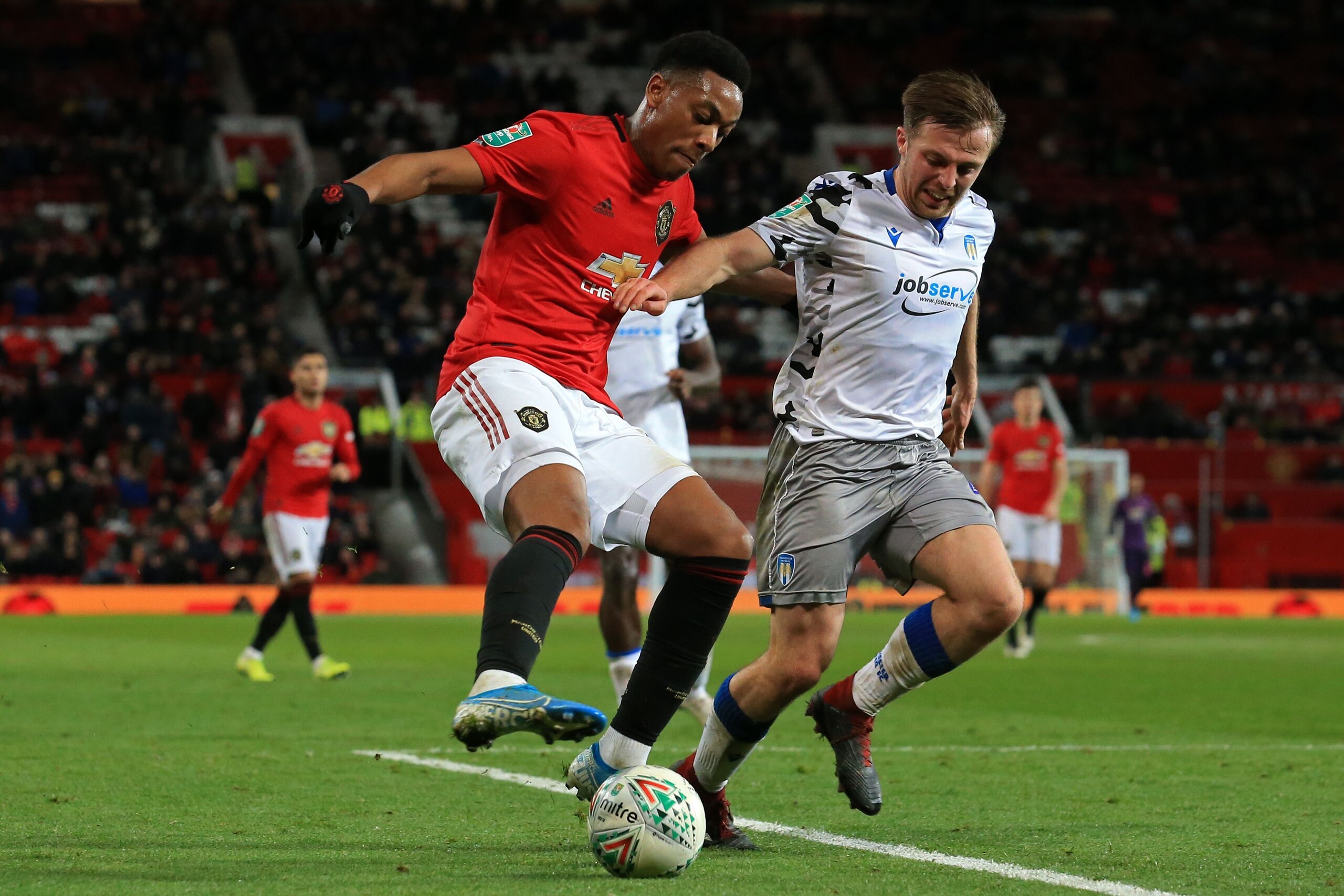 Manchester United's French striker Anthony Martial (L) vies with Colchester United's English midfielder Tom Lapslie (R) during the English League Cup quarter-final football match between Manchester United and Colchester United at Old Trafford in Manchester, north-west England on December 18, 2019. (Photo by Lindsey Parnaby / AFP) / RESTRICTED TO EDITORIAL USE. No use with unauthorized audio, video, data, fixture lists, club/league logos or 'live' services. Online in-match use limited to 120 images. An additional 40 images may be used in extra time. No video emulation. Social media in-match use limited to 120 images. An additional 40 images may be used in extra time. No use in betting publications, games or single club/league/player publications. /  (Photo by LINDSEY PARNABY/AFP via Getty Images)