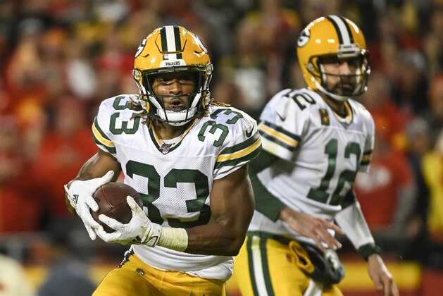 Green Bay Packers running back Aaron Jones (33) takes a hand-off from Green Bay Packers quarterback Aaron Rodgers (12) during the first half of an NFL football game against the Kansas City Chiefs in Kansas City, Mo., Sunday, Oct. 27, 2019. (AP Photo/Reed Hoffmann)