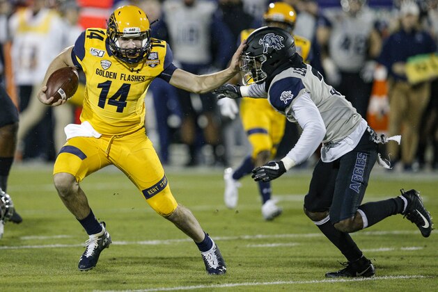 Kent State quarterback Dustin Crum (14) carries the ball as Utah State safety Troy Lefeged Jr. (3) defends during the first half of the Frisco Bowl NCAA college football game Friday, Dec. 20, 2019, in Frisco, Texas. (AP Photo/Brandon Wade)