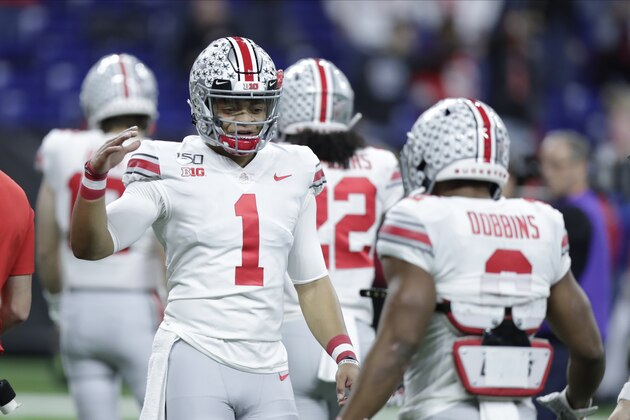 Ohio State quarterback Justin Fields talks with running back J.K. Dobbins (2) before the Big Ten championship NCAA college football game against Wisconsin, Saturday, Dec. 7, 2019, in Indianapolis. (AP Photo/Michael Conroy)