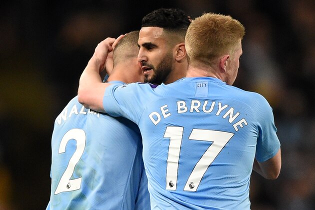 Manchester City's Algerian midfielder Riyad Mahrez (C) celebrates with teammates after scoring their first goal during the English Premier League football match between Manchester City and Leicester City at the Etihad Stadium in Manchester, north west England, on December 21, 2019. (Photo by Oli SCARFF / AFP) / RESTRICTED TO EDITORIAL USE. No use with unauthorized audio, video, data, fixture lists, club/league logos or 'live' services. Online in-match use limited to 120 images. An additional 40 images may be used in extra time. No video emulation. Social media in-match use limited to 120 images. An additional 40 images may be used in extra time. No use in betting publications, games or single club/league/player publications. /  (Photo by OLI SCARFF/AFP via Getty Images)