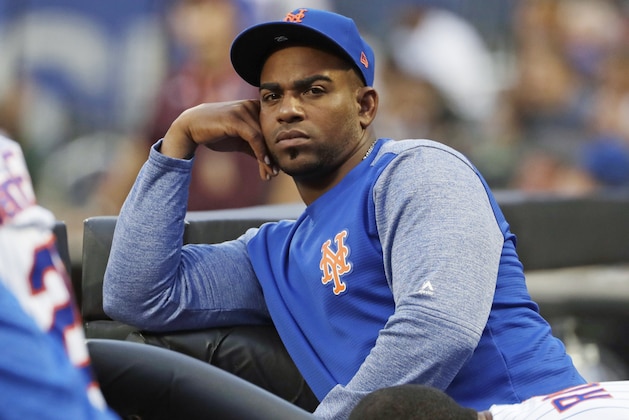 FILE - In this July 24, 2018, file photo, New York Mets' Yoenis Cespedes looks on as his team play the San Diego Padres during the first inning of a baseball game in New York. Cespedes' salary for 2019 was cut in half and his pay for 2020 reduced as part of a settlement of a grievance between the injured outfielder and the Mets. He agreed to a $110 million, four-year contract in December 2016 but has not played since July 20, 2018. The outfielder had surgery to remove bone calcification from his right heel on Aug. 2, 2018, and his left that Oct. 26. (AP Photo/Frank Franklin II, File)