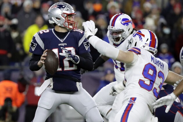 New England Patriots quarterback Tom Brady, left, passes under pressure from Buffalo Bills defensive end Trent Murphy (93) in the first half of an NFL football game, Saturday, Dec. 21, 2019, in Foxborough, Mass. (AP Photo/Elise Amendola)