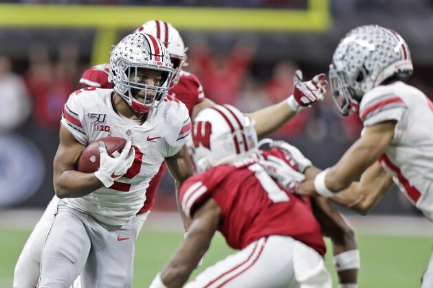 Ohio State running back J.K. Dobbins, left, runs with the ball during the first half of the team's Big Ten championship NCAA college football game against Wisconsin, Saturday, Dec. 7, 2019, in Indianapolis. (AP Photo/Michael Conroy)