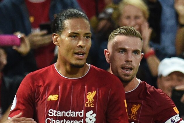 Liverpool's Dutch defender Virgil van Dijk (L) celebrates with Liverpool's English midfielder Jordan Henderson after he scores the team's third goal during the English Premier League football match between Liverpool and Norwich City at Anfield in Liverpool, north west England on August 9, 2019. (Photo by Oli SCARFF / AFP) / RESTRICTED TO EDITORIAL USE. No use with unauthorized audio, video, data, fixture lists, club/league logos or 'live' services. Online in-match use limited to 120 images. An additional 40 images may be used in extra time. No video emulation. Social media in-match use limited to 120 images. An additional 40 images may be used in extra time. No use in betting publications, games or single club/league/player publications. /         (Photo credit should read OLI SCARFF/AFP via Getty Images)