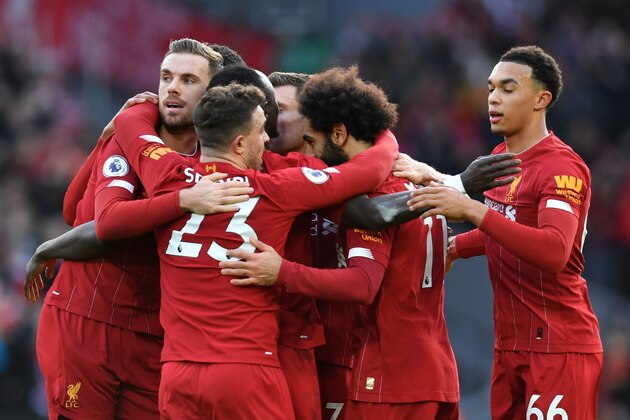 Liverpool's Egyptian midfielder Mohamed Salah celebrates with teammates after scoring his team's first goal during the English Premier League football match between Liverpool and Watford at Anfield in Liverpool, north west England on December 14, 2019. (Photo by Paul ELLIS / AFP) / RESTRICTED TO EDITORIAL USE. No use with unauthorized audio, video, data, fixture lists, club/league logos or 'live' services. Online in-match use limited to 120 images. An additional 40 images may be used in extra time. No video emulation. Social media in-match use limited to 120 images. An additional 40 images may be used in extra time. No use in betting publications, games or single club/league/player publications. /  (Photo by PAUL ELLIS/AFP via Getty Images)
