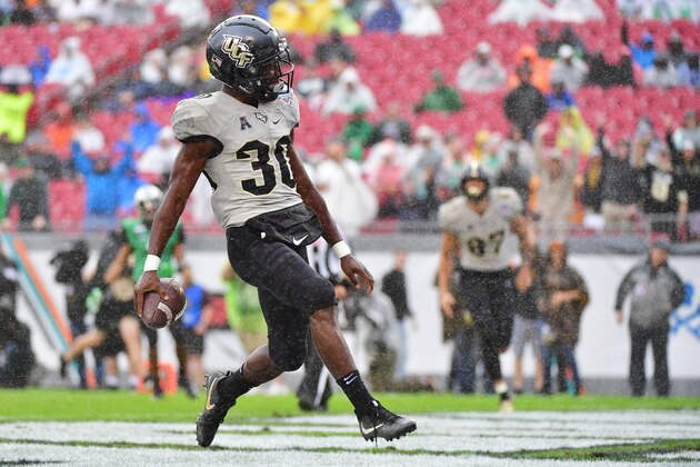 TAMPA, FLORIDA - DECEMBER 23: Greg McCrae #30 of the UCF Knights scores during the first quarter against the Marshall Thundering Herd at the Bad Boy Mowers Gasparilla Bowl at Raymond James Stadium on December 23, 2019 in Tampa, Florida. (Photo by Julio Aguilar/Getty Images) TAMPA, FLORIDA - DECEMBER 23: Greg McCrae #30 of the UCF Knights scores during the first quarter against the Marshall Thundering Herd at the Bad Boy Mowers Gasparilla Bowl at Raymond James Stadium on December 23, 2019 in Tampa, Florida. (Photo by Julio Aguilar/Getty Images)