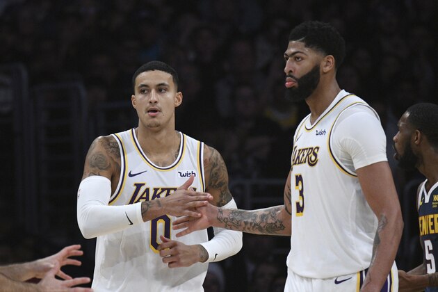 Los Angeles Lakers forward Kyle Kuzma, left, and forward Anthony Davis slap hands during an NBA basketball game against the Denver Nuggets Sunday, Dec. 22, 2019, in Los Angeles. (AP Photo/Michael Owen Baker)