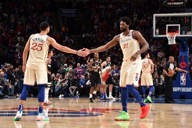 PHILADELPHIA, PA - DECEMBER 25: Ben Simmons #25, and Joel Embiid #21 of the Philadelphia 76ers react to a play against the Milwaukee Bucks on December 25, 2019 at the Wells Fargo Center in Philadelphia, Pennsylvania. NOTE TO USER: User expressly acknowledges and agrees that, by downloading and/or using this Photograph, user is consenting to the terms and conditions of the Getty Images License Agreement. Mandatory Copyright Notice: Copyright 2019 NBAE (Photo by David Dow/NBAE via Getty Images)