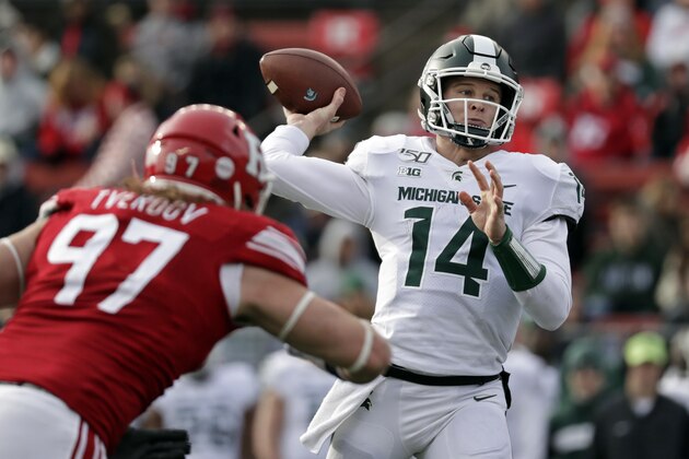 Michigan State quarterback Brian Lewerke (14) passes under pressure from Rutgers defensive lineman Mike Tverdov (97) during the second half of an NCAA college football game Saturday, Nov. 23, 2019, in Piscataway, N.J. Michigan State won 27-0. (AP Photo/Adam Hunger)