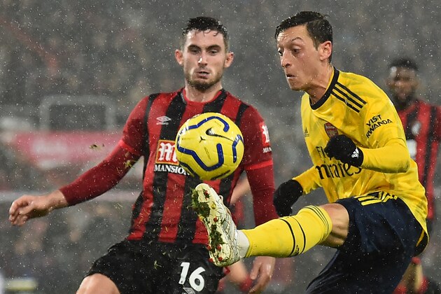 Bournemouth's English midfielder Lewis Cook (L) vies with Arsenal's German midfielder Mesut Ozil during the English Premier League football match between Bournemouth and Arsenal at the Vitality Stadium in Bournemouth, southern England on December 26, 2019. (Photo by Glyn KIRK / AFP) / RESTRICTED TO EDITORIAL USE. No use with unauthorized audio, video, data, fixture lists, club/league logos or 'live' services. Online in-match use limited to 120 images. An additional 40 images may be used in extra time. No video emulation. Social media in-match use limited to 120 images. An additional 40 images may be used in extra time. No use in betting publications, games or single club/league/player publications. /  (Photo by GLYN KIRK/AFP via Getty Images)