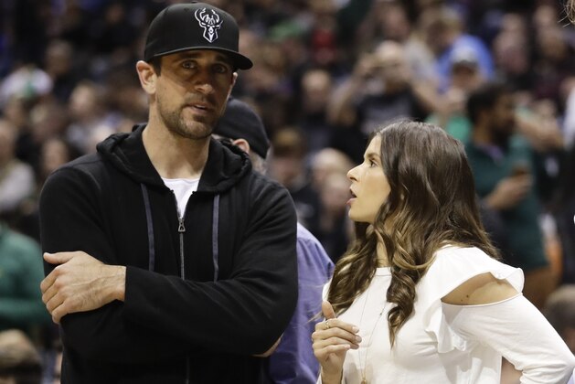 Danica Patrick talks to Green Bay Packers' Aaron Rodgers during the first half of Game 3 of an NBA basketball first-round playoff series between the Milwaukee Bucks and the Boston Celtics Friday, April 20, 2018, in Milwaukee. (AP Photo/Morry Gash)