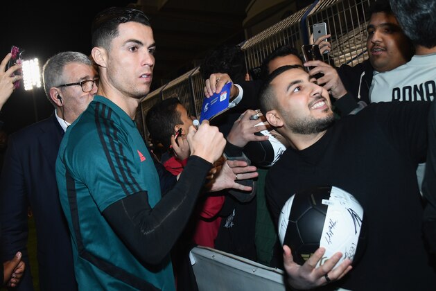 RIYADH, SAUDI ARABIA - DECEMBER 21:  Cristiano Ronaldo of Juventus signing autographs and taking selfie before the training session on December 22, 2019 in Riyadh, Saudi Arabia.  (Photo by Claudio Villa/Getty Images for Lega Serie A)