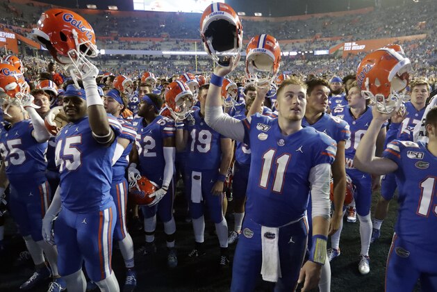 Florida players, including quarterback Kyle Trask (11), celebrate in front of fans after defeating Florida State in an NCAA college football game, Saturday, Nov. 30, 2019, in Gainesville, Fla. (AP Photo/John Raoux)