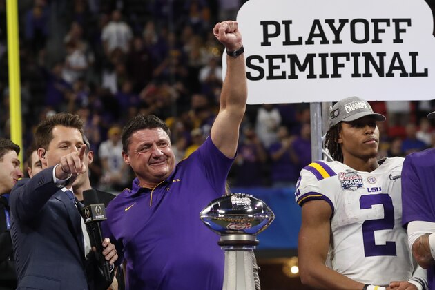 LSU coach Ed Orgeron and the team celebrate winning the Peach Bowl NCAA semifinal college football playoff game against Oklahoma, Saturday, Dec. 28, 2019, in Atlanta. LSU won 63-28. (AP Photo/John Bazemore)