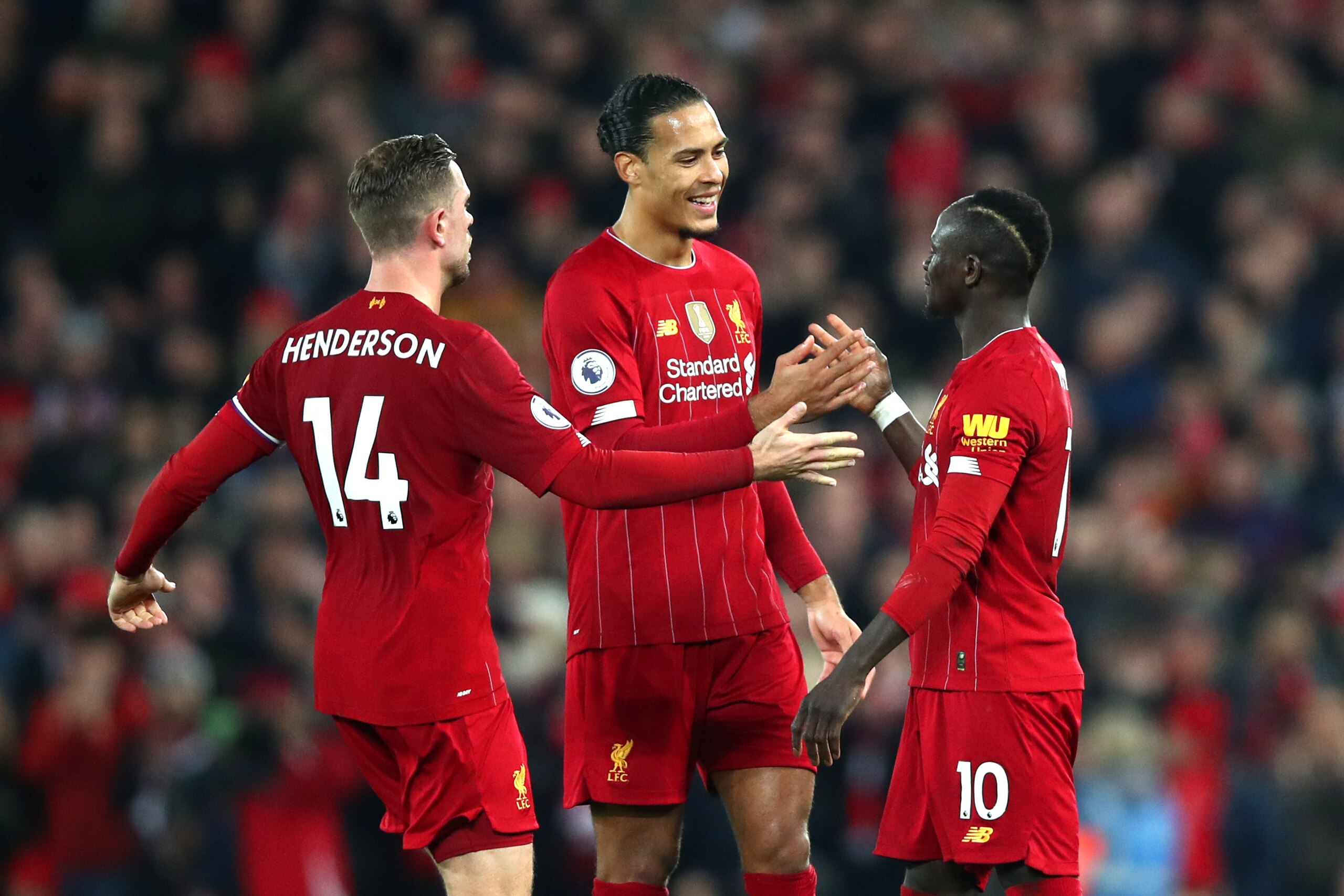 LIVERPOOL, ENGLAND - DECEMBER 29: Sadio Mane of Liverpool celebrates with Virgil van Dijk of Liverpool and Jordan Henderson of Liverpool after scoring his sides first goal during the Premier League match between Liverpool FC and Wolverhampton Wanderers at Anfield on December 29, 2019 in Liverpool, United Kingdom. (Photo by Clive Brunskill/Getty Images)