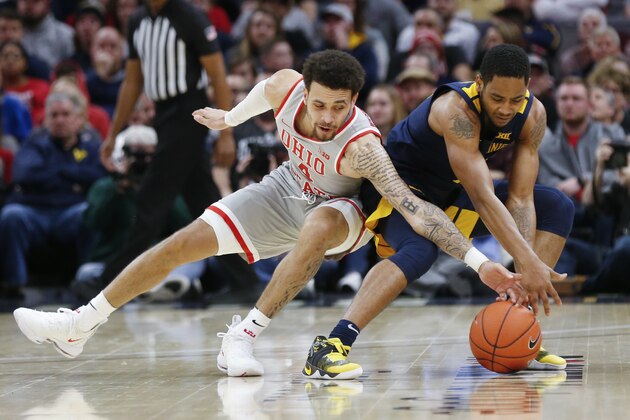 Ohio State's Duane Washington (4) and West Virginia's Taz Sherman (12) battle for a loose ball during the first half of an NCAA college basketball game Sunday, Dec. 29, 2019, in Cleveland. (AP Photo/Ron Schwane)