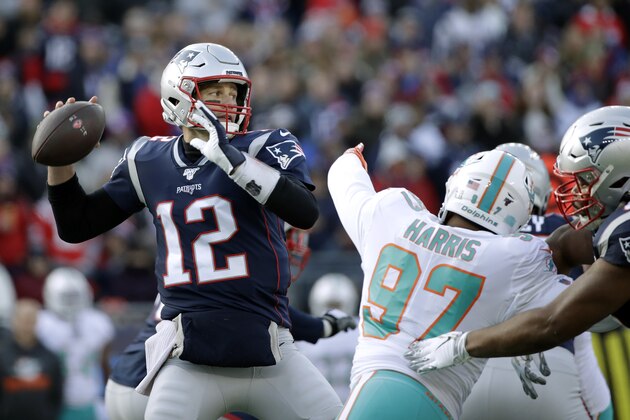 New England Patriots quarterback Tom Brady, left, passes under pressure from Miami Dolphins defensive end Trent Harris in the first half of an NFL football game, Sunday, Dec. 29, 2019, in Foxborough, Mass. (AP Photo/Elise Amendola)