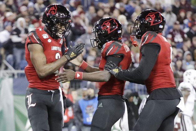 Louisville wide receiver Devante Peete, left, celebrates with quarterback Micale Cunningham, center, after they teamed up for a 24-yard pass completion for a touchdown against Mississippi State in the second half of the Music City Bowl NCAA college football game Monday, Dec. 30, 2019, in Nashville, Tenn. (AP Photo/Mark Humphrey)