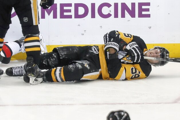 Pittsburgh Penguins' Jake Guentzel (59) rolls on the ice after being injured after scoring a goal against the Ottawa Senators during the third period of an NHL hockey game, Monday, Dec. 30, 2019, in Pittsburgh. Guentzel left the ice and did not return to the game. (AP Photo/Keith Srakocic)