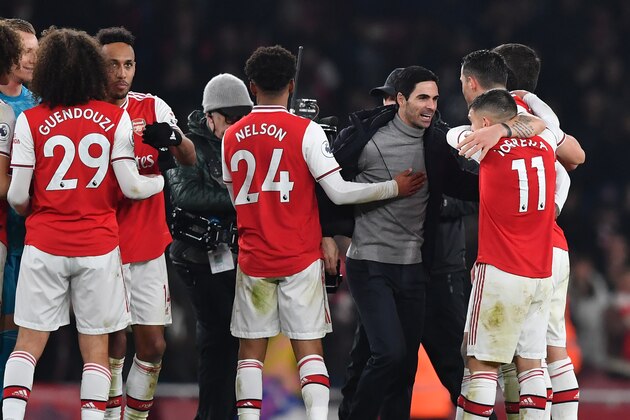 Arsenal's Spanish head coach Mikel Arteta (C) celebrates with his players on the pitch after the English Premier League football match between Arsenal and Manchester United at the Emirates Stadium in London on January 1, 2020. - Arsenal won the game 2-0. (Photo by Ben STANSALL / AFP) / RESTRICTED TO EDITORIAL USE. No use with unauthorized audio, video, data, fixture lists, club/league logos or 'live' services. Online in-match use limited to 120 images. An additional 40 images may be used in extra time. No video emulation. Social media in-match use limited to 120 images. An additional 40 images may be used in extra time. No use in betting publications, games or single club/league/player publications. /  (Photo by BEN STANSALL/AFP via Getty Images)